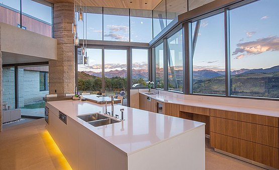 b3 kitchen in walnut and alpine white lacquer featuring an angled installation to follow the line of the architecture that showcases beautiful mountain views from expansive windows.