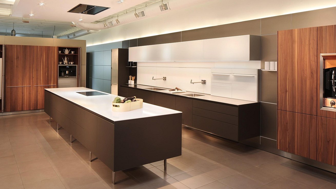b3 kitchen in soft touch lacquer Cashmere, Solid walnut, glass wall cabinets and panels, featuring foot mounted island and hanging kitchen with tall pocket door cabinets open. 