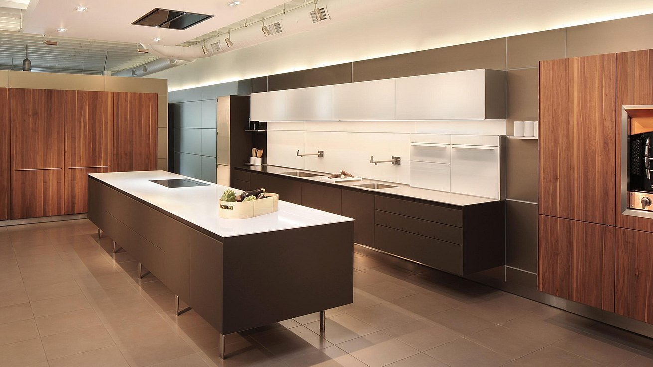 b3 kitchen in soft touch lacquer Cashmere, Solid walnut, glass wall cabinets and panels, featuring foot mounted island and hanging kitchen with tall pocket door cabinets closed. 